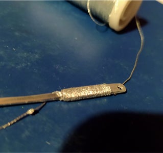 WRAPPING SILVER THREAD ON THE HANDLE.