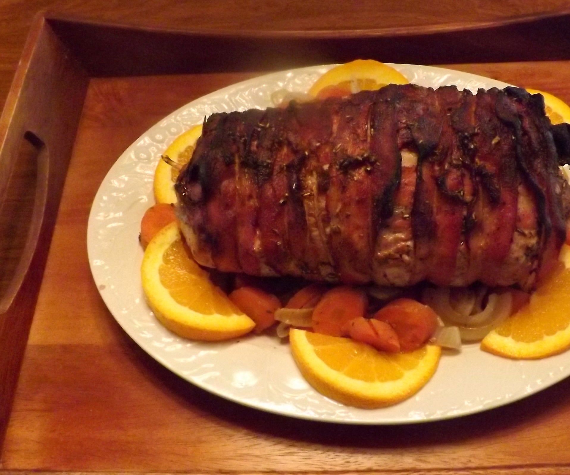 BACON WRAPPED PORK LOIN STUFFED WITH APRICOTS, CRAISINS & PINE NUTS