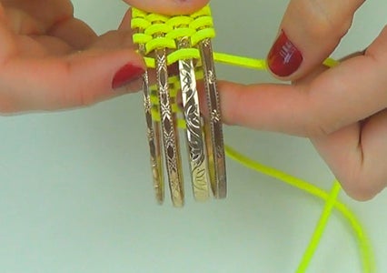 Take 4 Thin Bangles From the Set and Start to Insert the Leather Lace Among Them, in a Meandering Way. 
