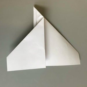 Next, Fold Down One of the Wings a Few Inches Past the Body of the Plane, Making a Fold That Is Straight All the Way Across. 