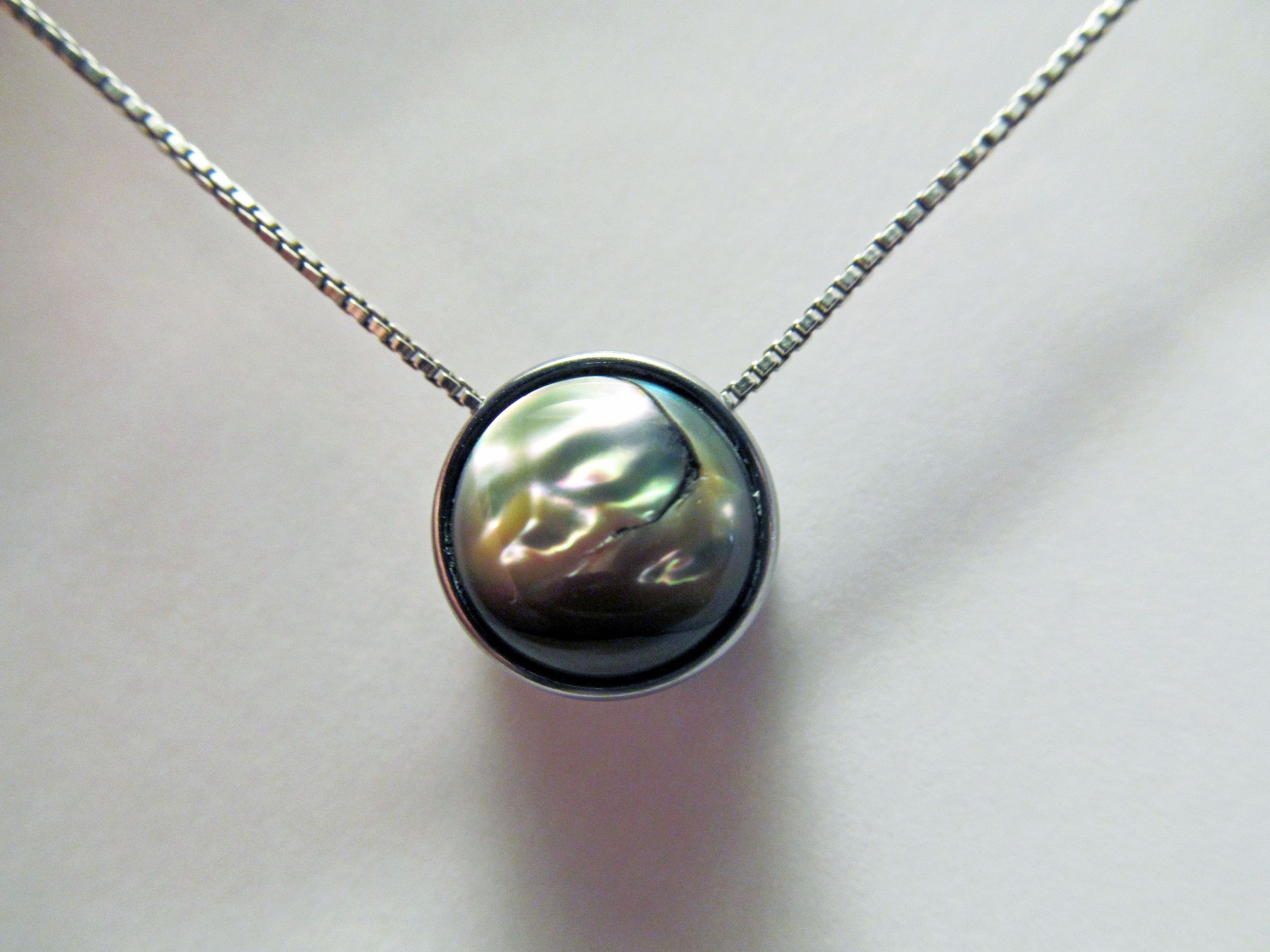 A Steel and Sea Shell Pendant
