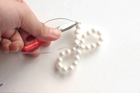Thread Extra 3~4 Pearl Beads Onto Each Wire Tail and Secure the Beads With Knots. Trim Off the Leftover Wires.