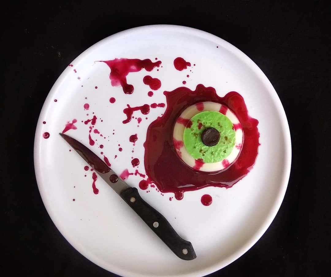 HALLOWEEN SPOOKY BLOODY EYEBALL Representing Coconut Milk and Banana Pudding With a Twist of Beetroot Sauce .