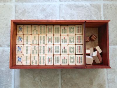 An early 20th Century butterscotch Bakelite Mah Jong set in a carved wooden box An early 20th Century butterscotch Bakelite Mah Jong set in a carved wooden box