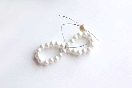 Add on Another Piece of Pearl Bead on Surface by Crossing With Two Exposed Wire Ends.