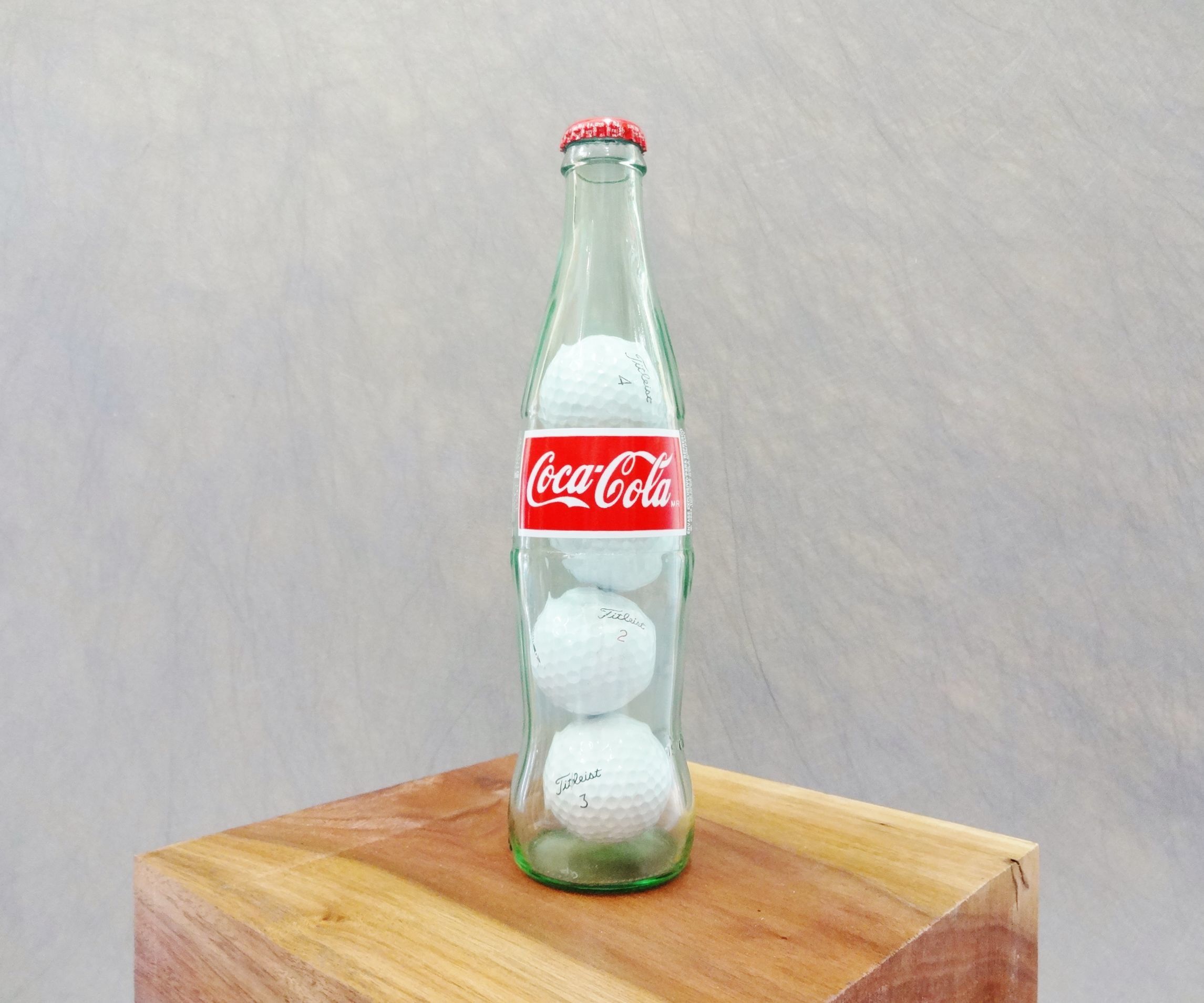 Golf balls in a Coke bottle